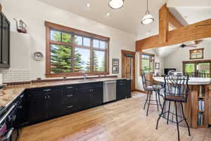 Gourmet kitchen featuring black cabinetry, light granite countertops, and white subway tile backsplash