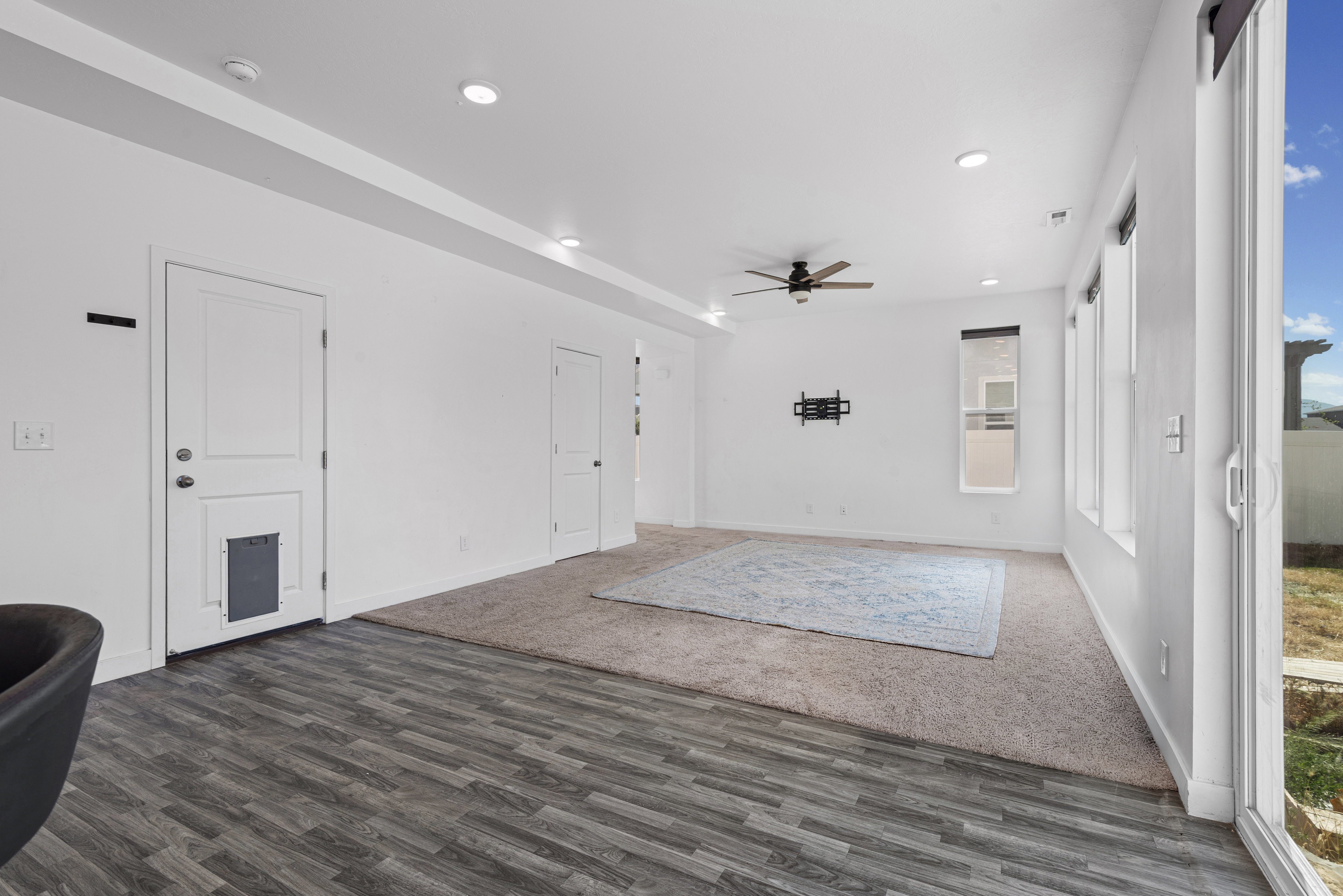 Spacious interior featuring a combination of wood-finish flooring and carpet