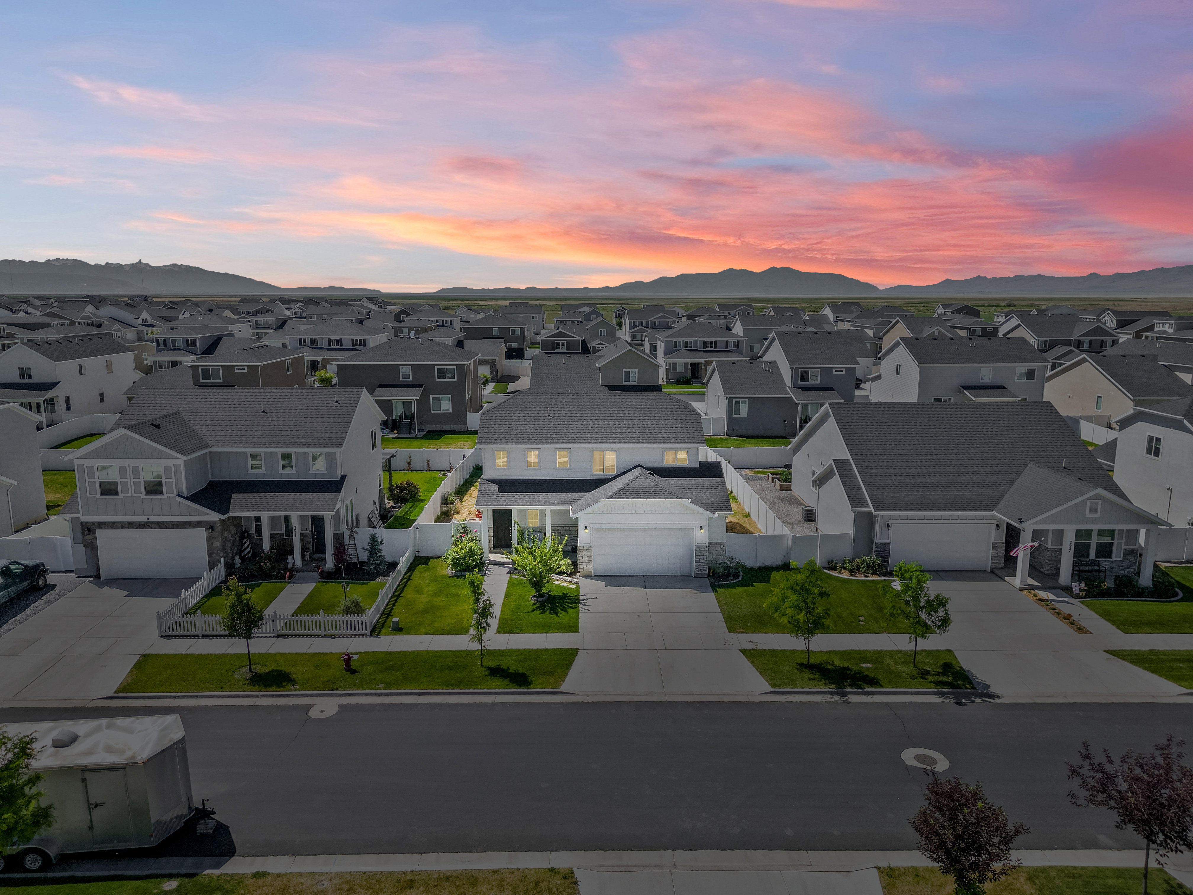 Contemporary two-story residence featuring a light gray exterior and dark shingle roof