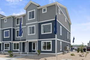 Contemporary multi-level townhome featuring a two-tone exterior with blue vertical siding and gray horizontal siding