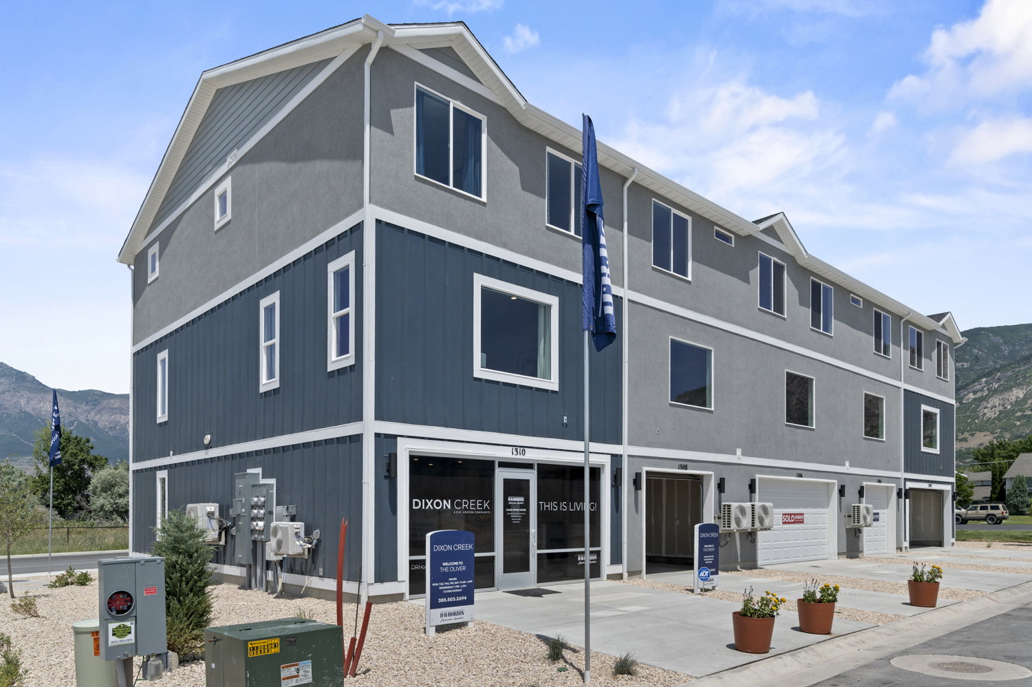 Multi-story townhouse-style structure featuring a contemporary facade with stucco and vertical siding