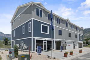 Multi-story townhouse-style structure featuring a contemporary facade with stucco and vertical siding