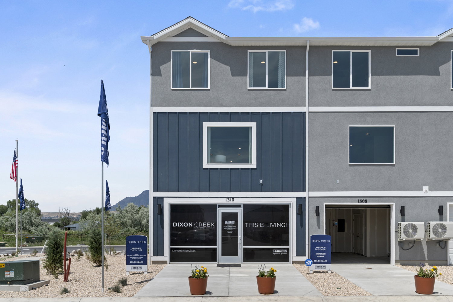 Contemporary townhome exterior featuring a blue vertical siding accent, light gray stucco, and white trim
