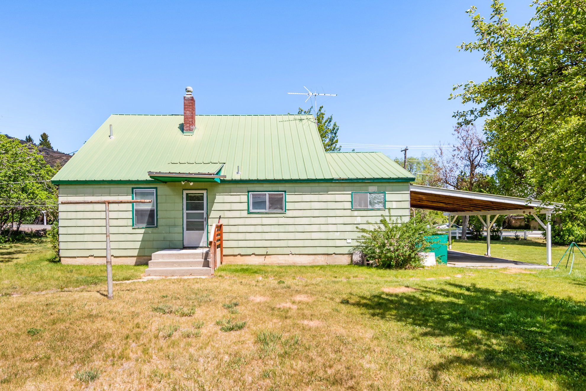 Light green siding exterior with a bright green metal roof