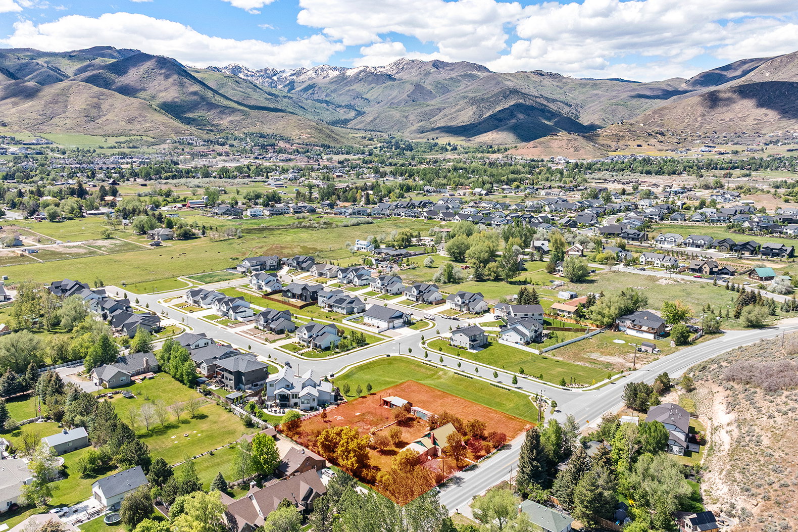 Aerial perspective showcasing a residential area set against a mountainous backdrop