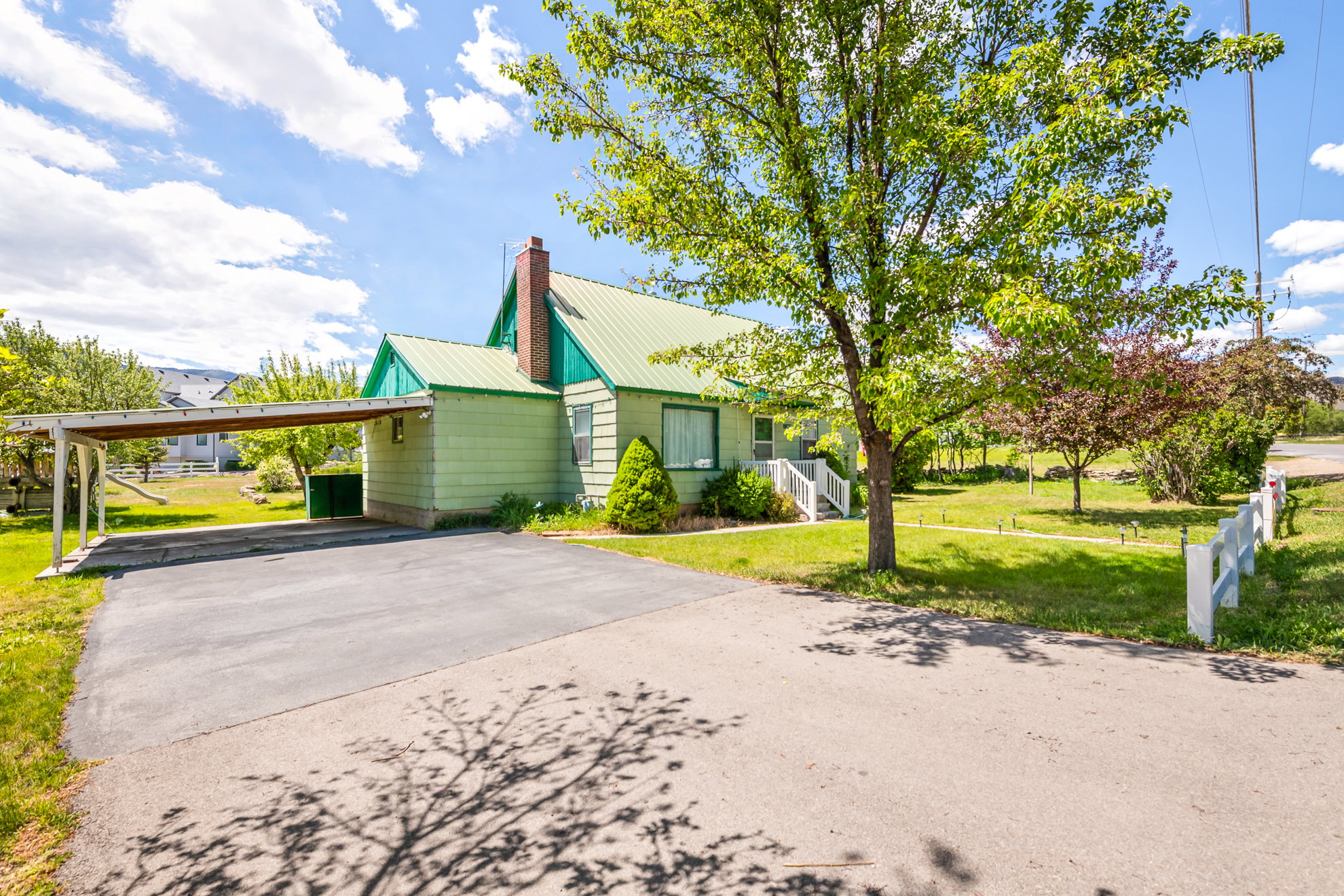 Light green siding exterior with a green metal roof