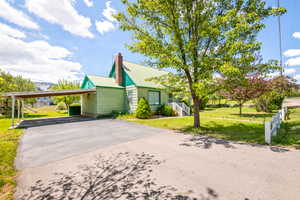 Light green siding exterior with a green metal roof