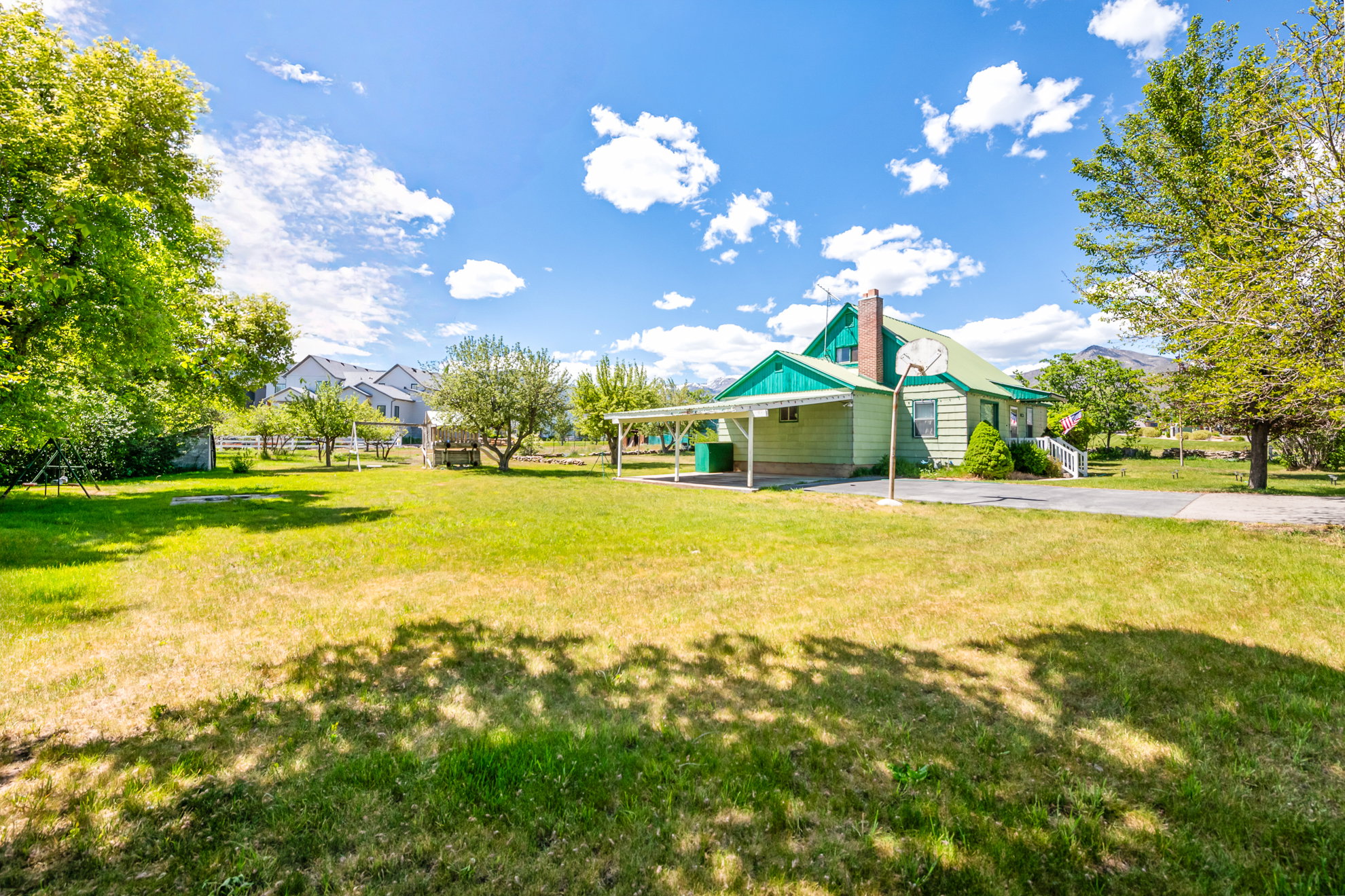Expansive grassy yard with mature trees