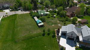 Expansive grass lot with mature trees, offering a street-front location and proximity to developed residential properties