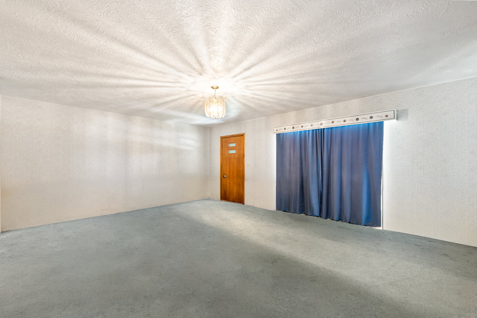 Spacious room with light blue carpeting and textured white walls