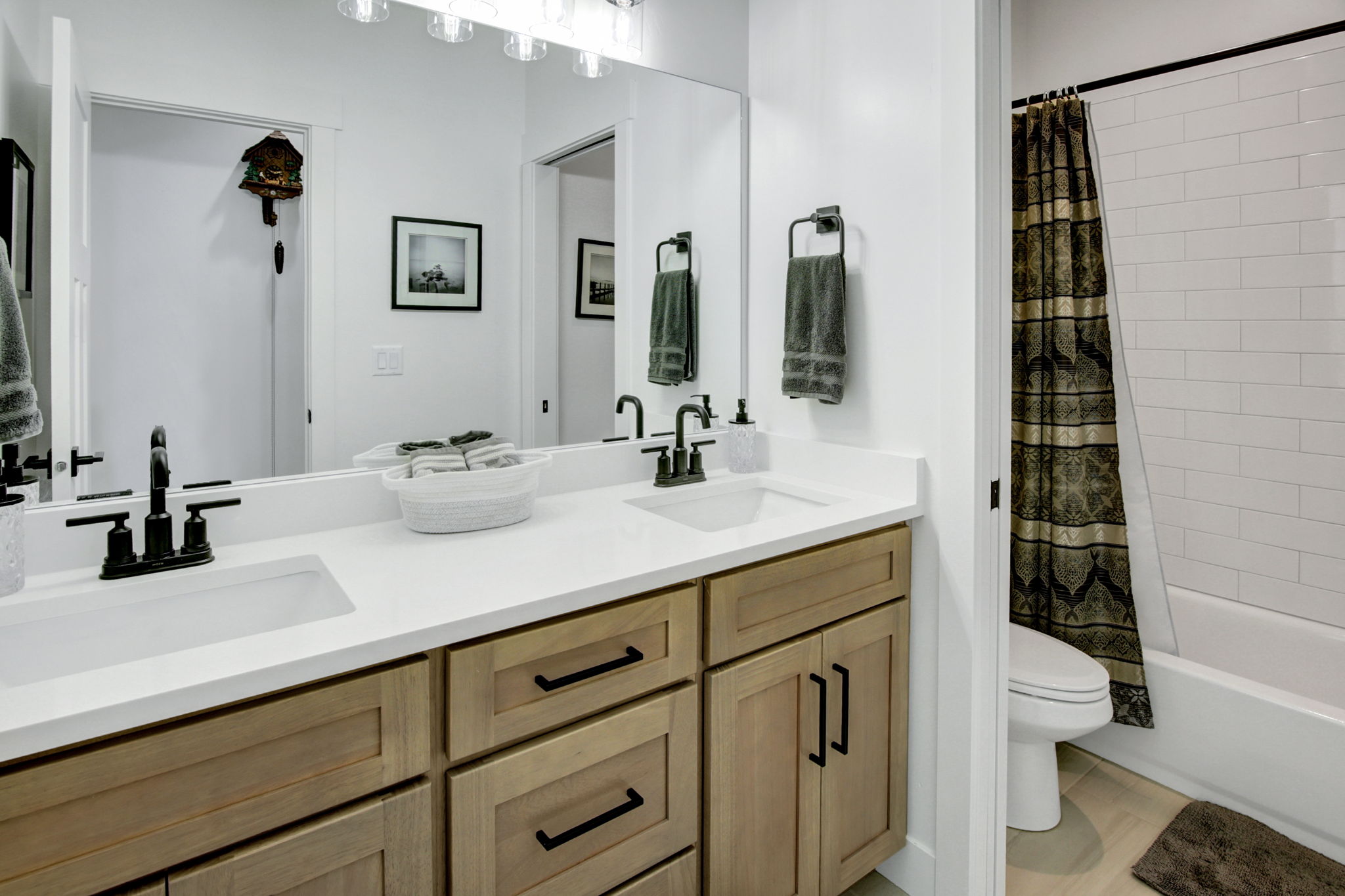 Dual vanity with wood cabinetry and matte black fixtures