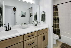Dual vanity with wood cabinetry and matte black fixtures