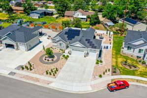 Modern residence featuring a stone and siding exterior, a multi-car driveway, and a Xeriscaped front yard with decorative plantings