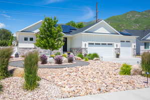Modern ranch-style exterior featuring white vertical siding and stone veneer accents
