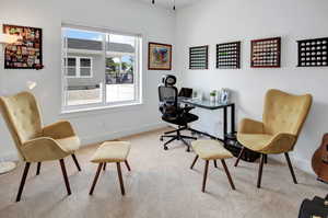 Bright room featuring white walls, a large window, and light-colored carpeting