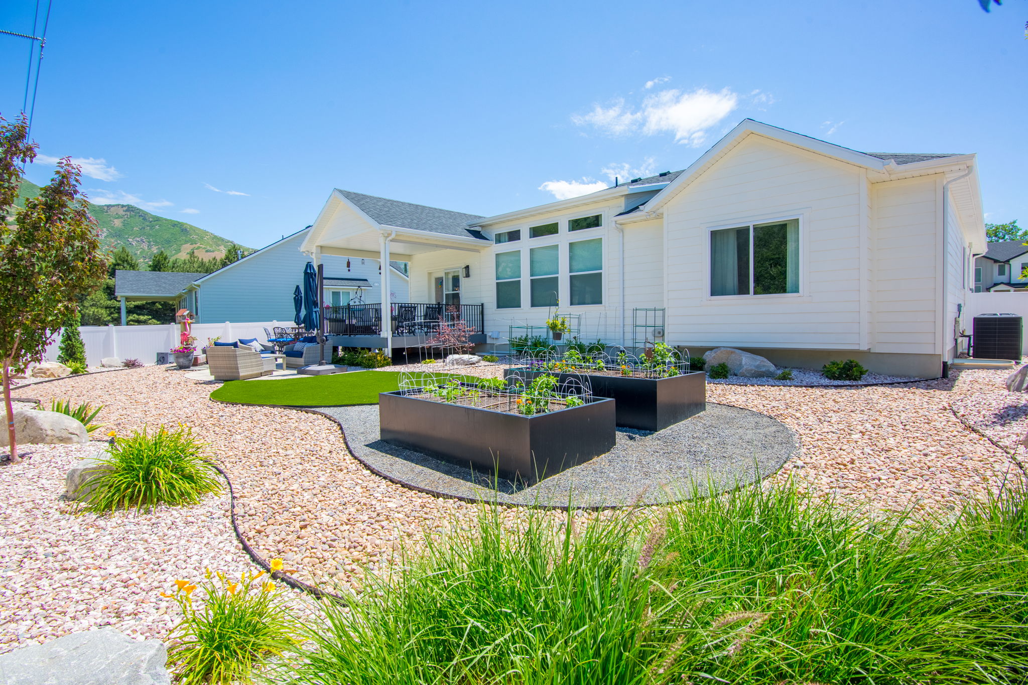 Contemporary backyard featuring drought-tolerant landscaping with gravel paths and decorative rocks