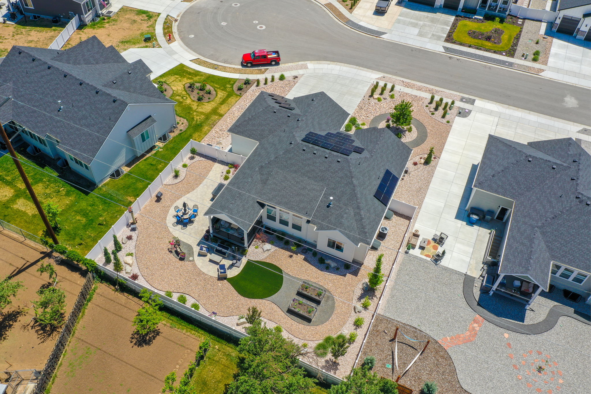 Aerial perspective showcasing a contemporary residence with a dark shingle roof and solar panels