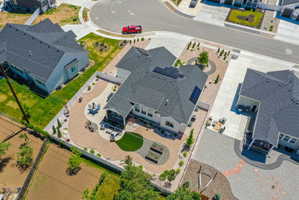 Aerial perspective showcasing a contemporary residence with a dark shingle roof and solar panels