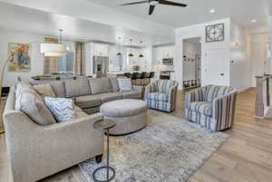 Open-concept living area featuring light LVP flooring, recessed lighting, and a contemporary ceiling fan