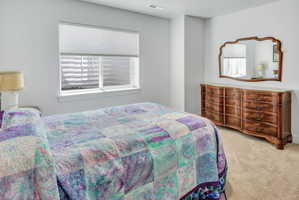 Carpeted interior space featuring a window with cellular shades, a white window frame, and neutral wall tones