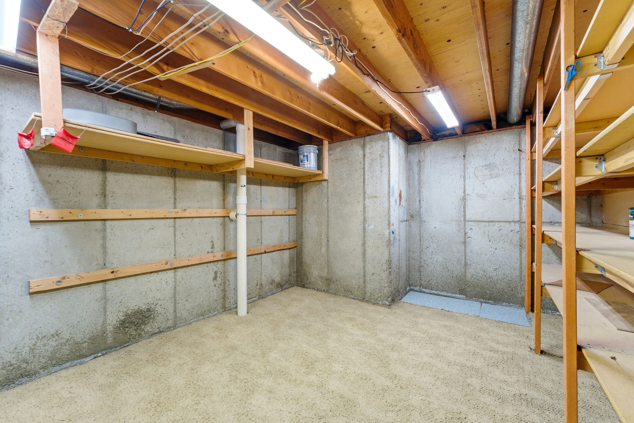 Utility space featuring exposed wood ceiling joists and concrete block walls