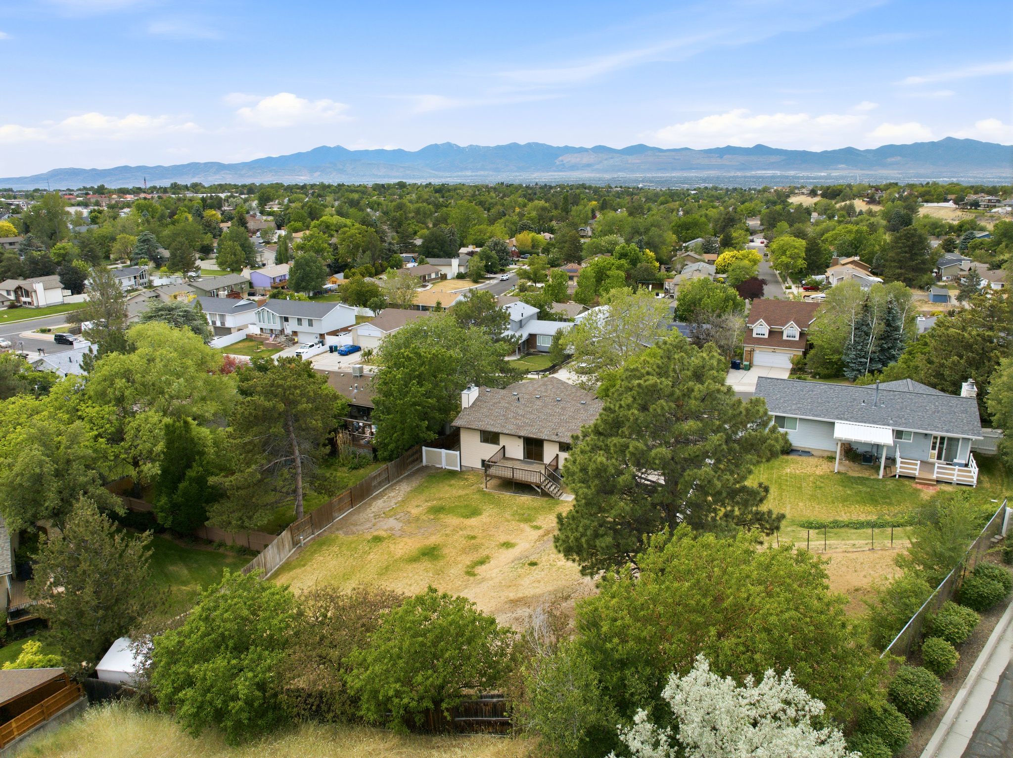 Expansive lot featuring mature trees and a sloped terrain