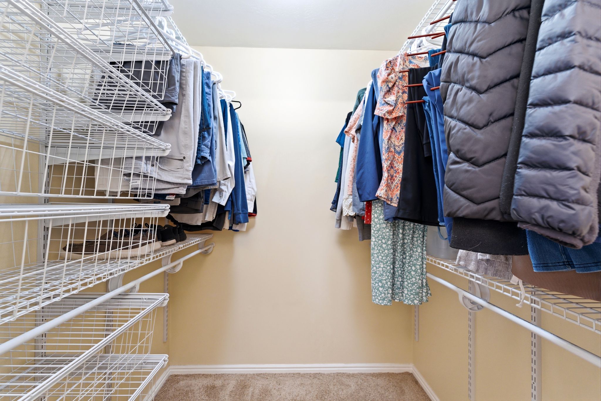 Walk-in closet featuring built-in wire shelving and hanging rods