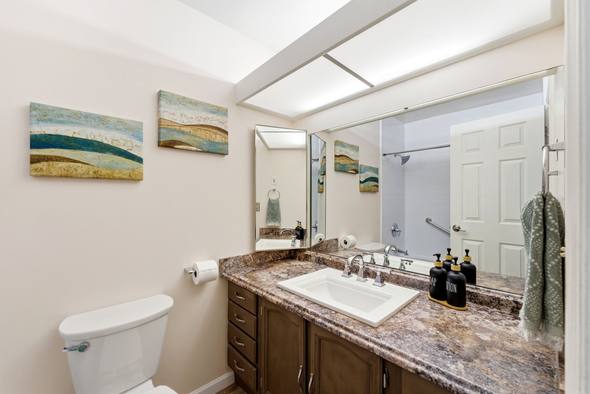 Vanity featuring a rectangular undermount sink, dual-handle faucet, and mottled countertop