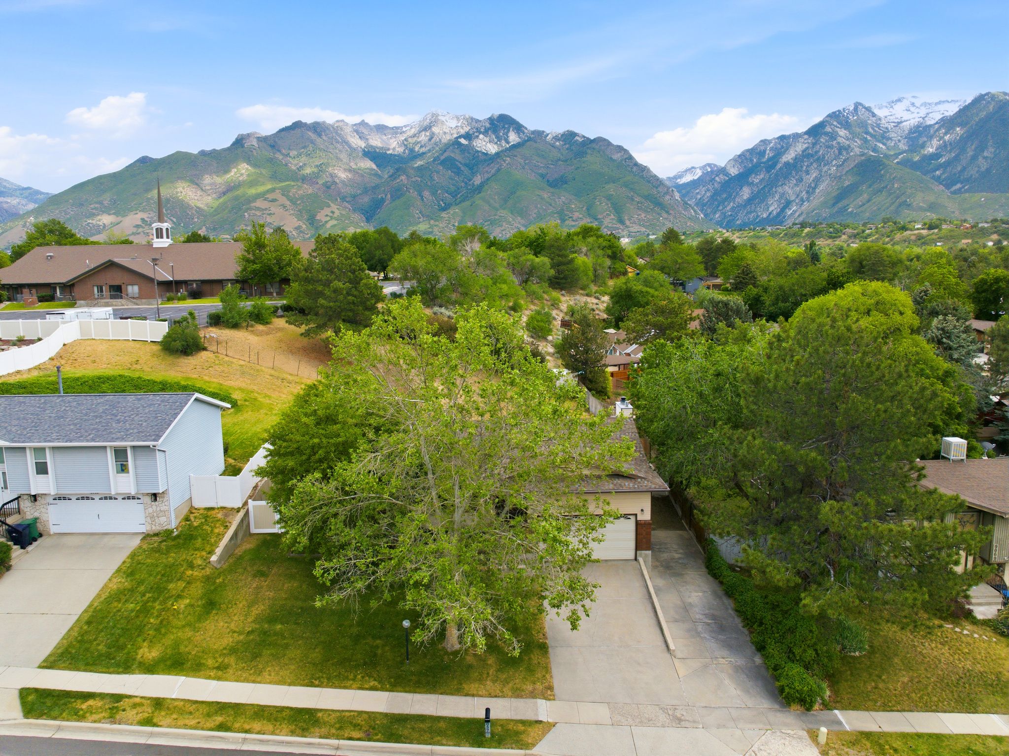 Residential properties featuring established landscaping, mountain scenery, and paved driveways