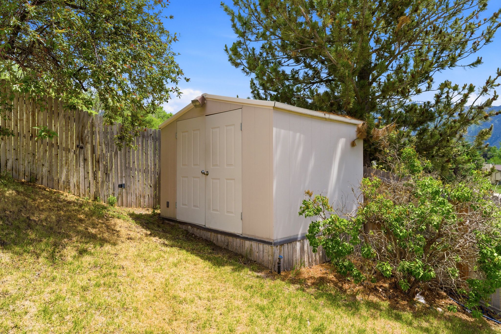 Exterior storage shed featuring double doors and a sloped roof