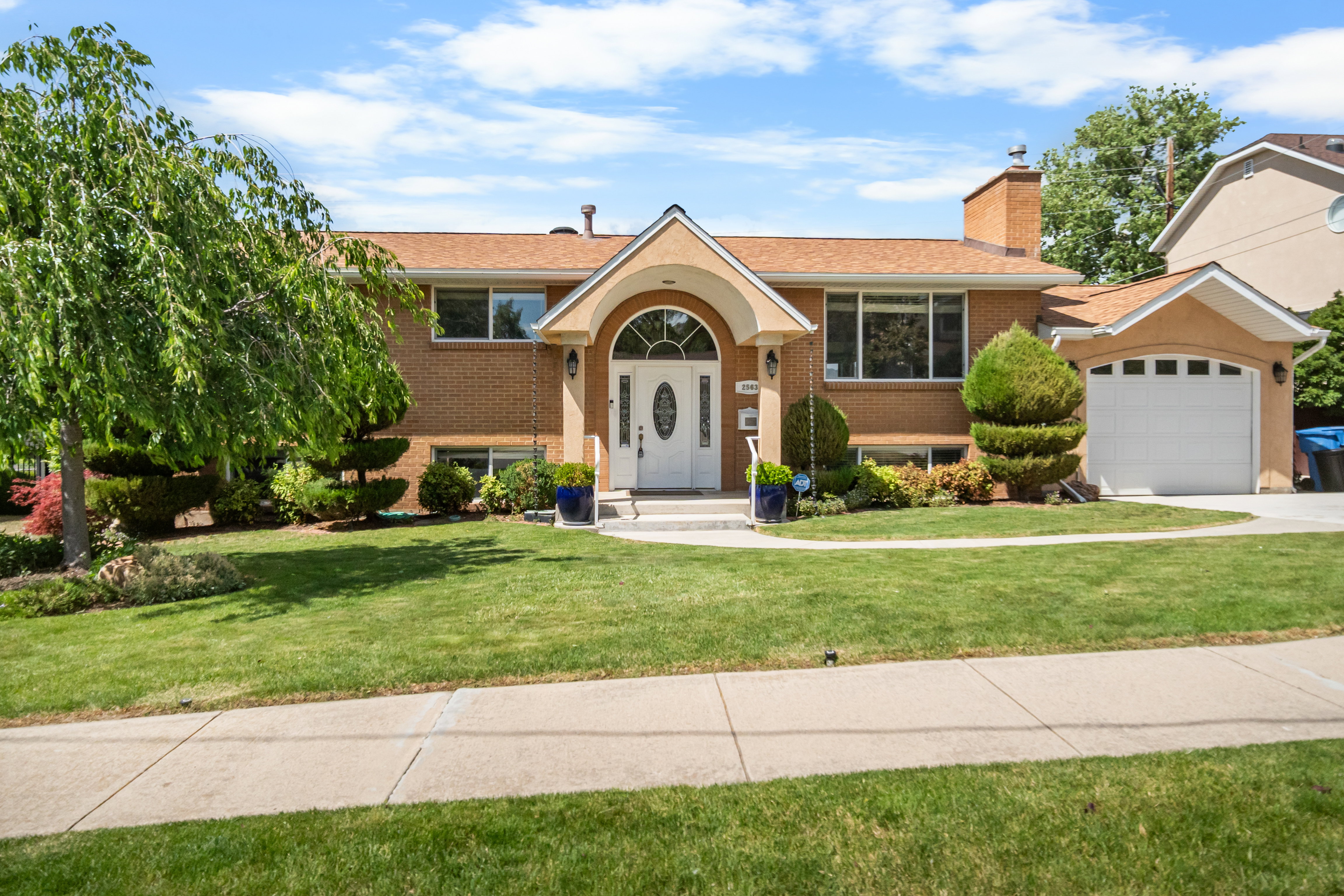 Brick and stucco exterior featuring an arched entryway with a white door and sidelights