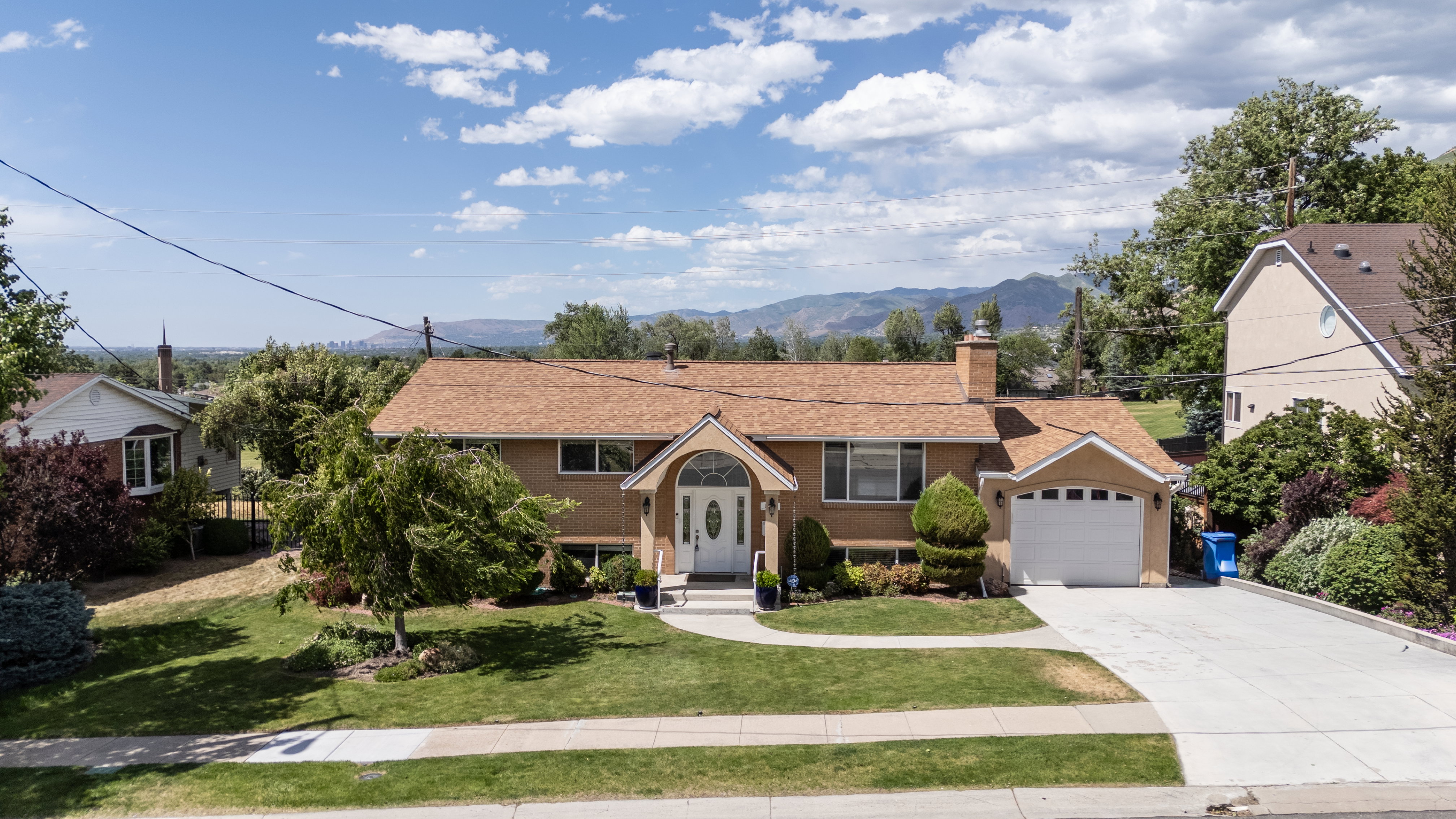 Single-family residence featuring a prominent arched entry, attached garage, and a manicured front lawn