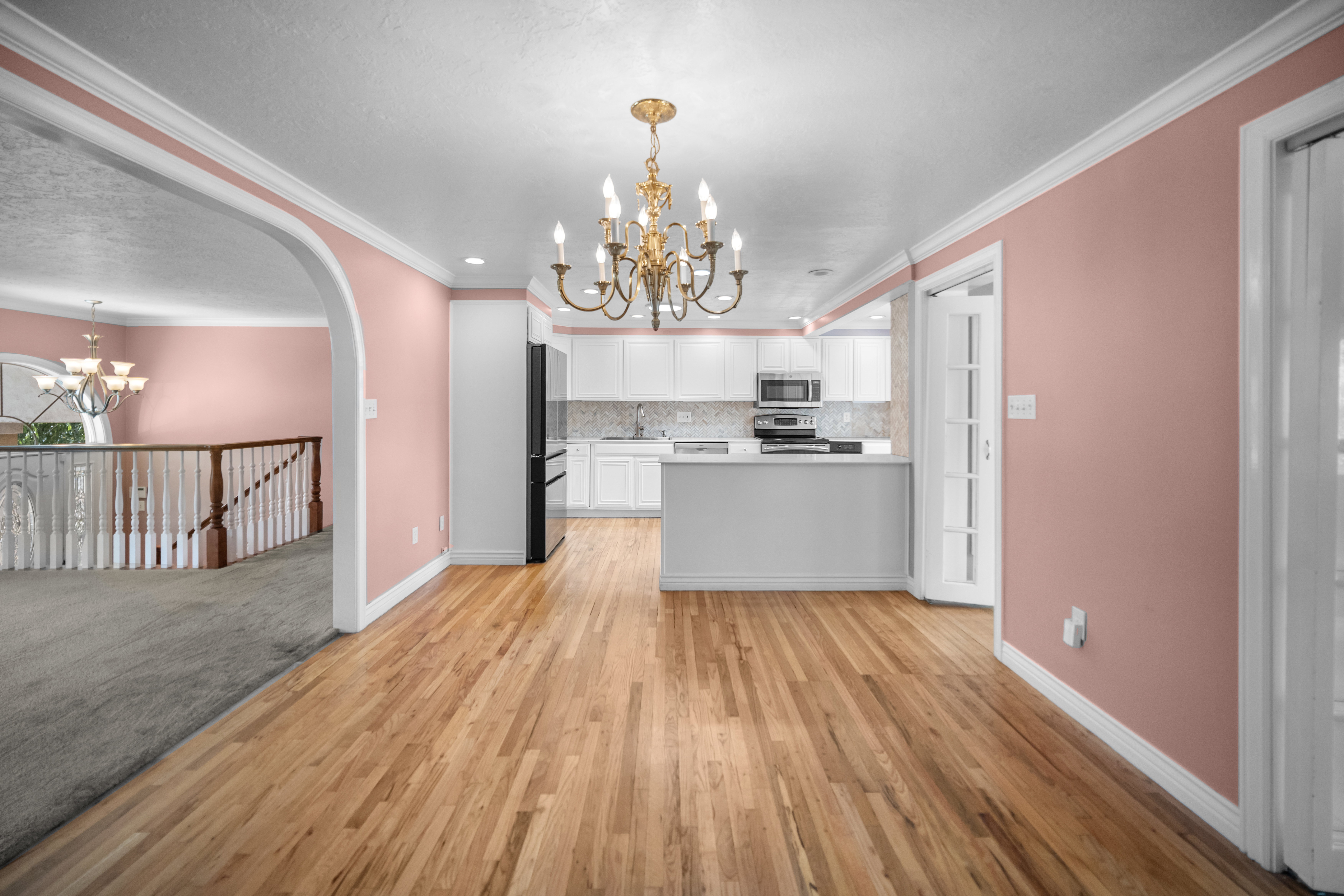 Open concept main living space featuring wood-finish flooring and a brass chandelier