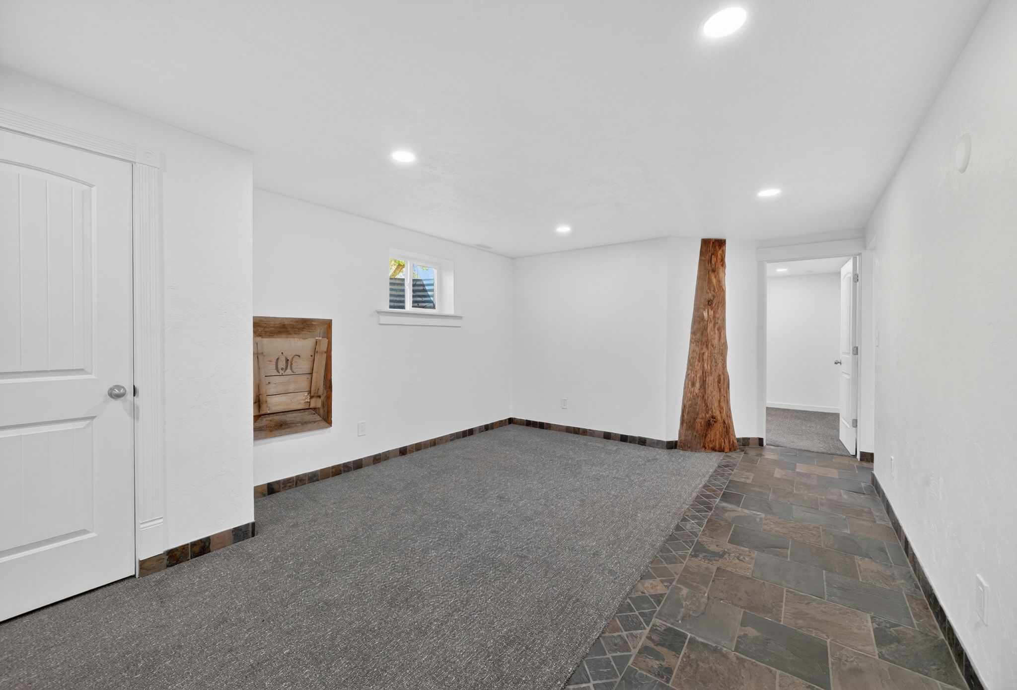 Spacious room featuring recessed lighting, a window with louvered shutters, and a unique wood architectural element