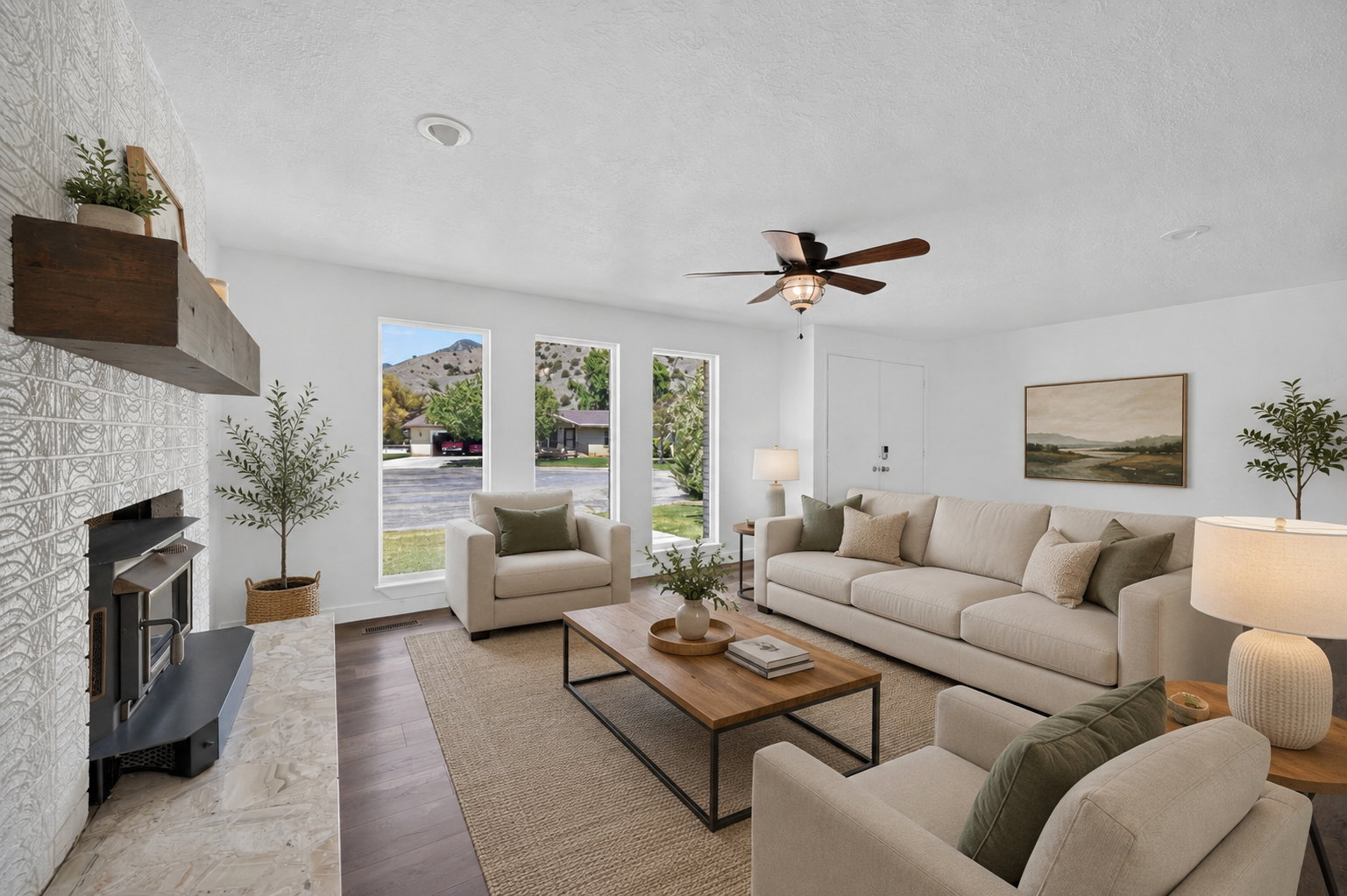 Virtual staging included to showcase room potential. Bright living space featuring a tiled fireplace with a wood mantle, wood-finish flooring, a ceiling fan, and multiple large windows