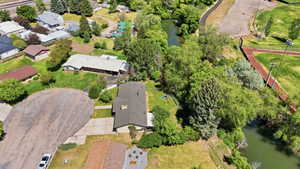 Aerial perspective showcasing a residential property with a dark shingle roof and an attached garage