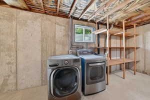 Unfinished basement space featuring exposed concrete walls, a small horizontal window, open wood shelving, and exposed ceiling joists