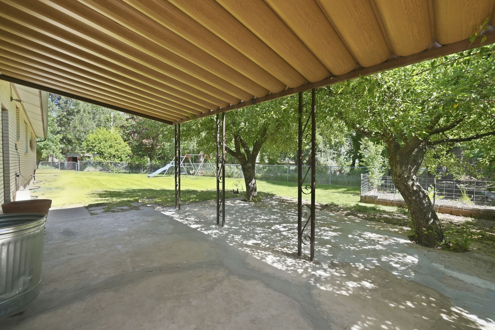 Covered concrete patio with decorative metal support posts