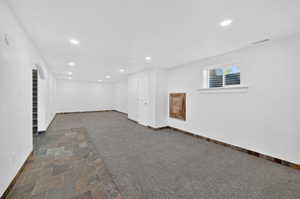 Spacious room featuring mixed flooring with large format tiles and carpeting