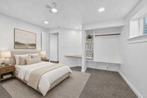 Virtual staging included to showcase room potential. Bedroom featuring built-in shelving, a clothes rod, a built-in desk, a ceiling fan, and recessed lighting