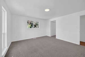 White-painted interior room with grey carpet flooring