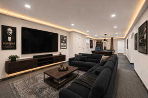 Virtual staging included to showcase room potential. Spacious recreation area featuring a large built-in media console, recessed lighting, and accent cove lighting