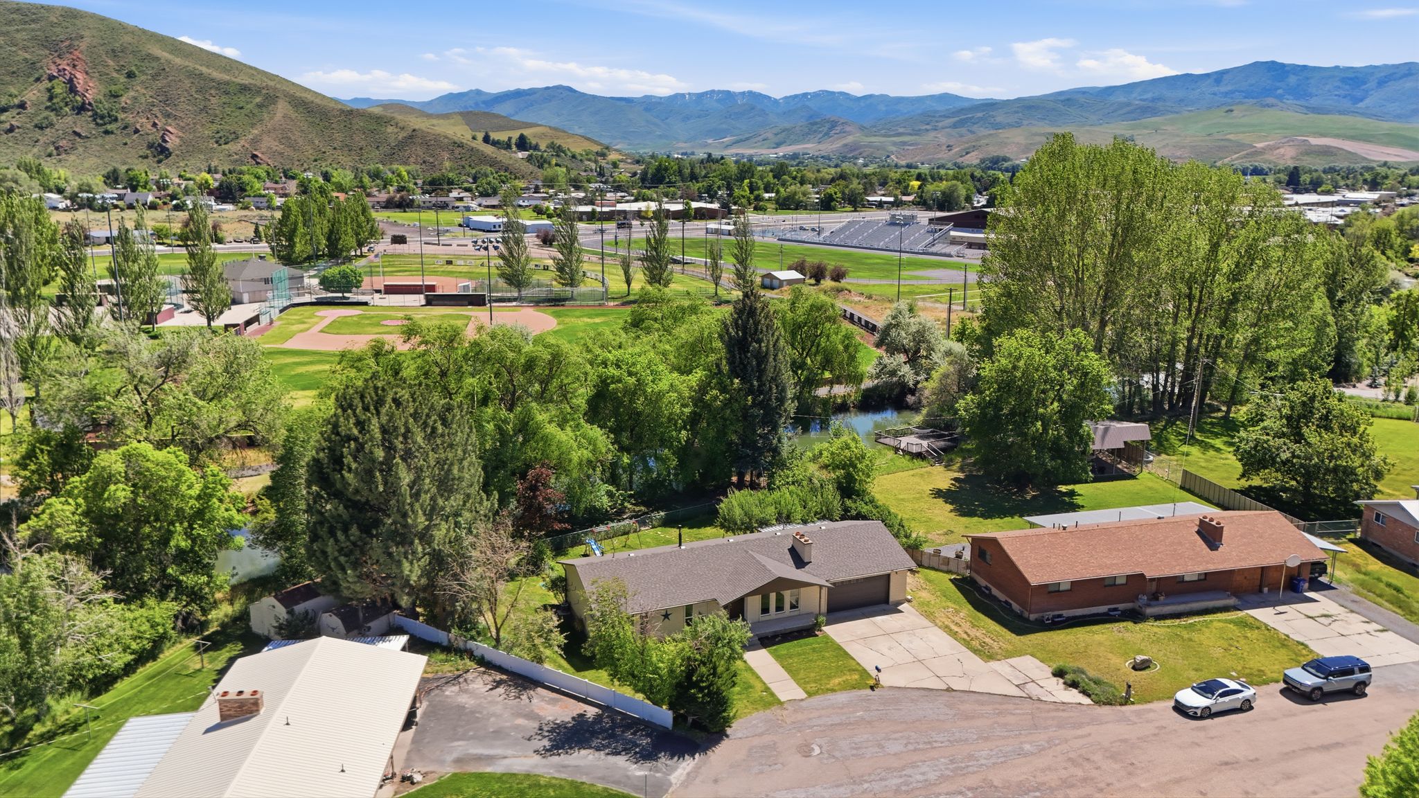 Aerial perspective showcasing the residential area with surrounding green spaces and mountain backdrop
