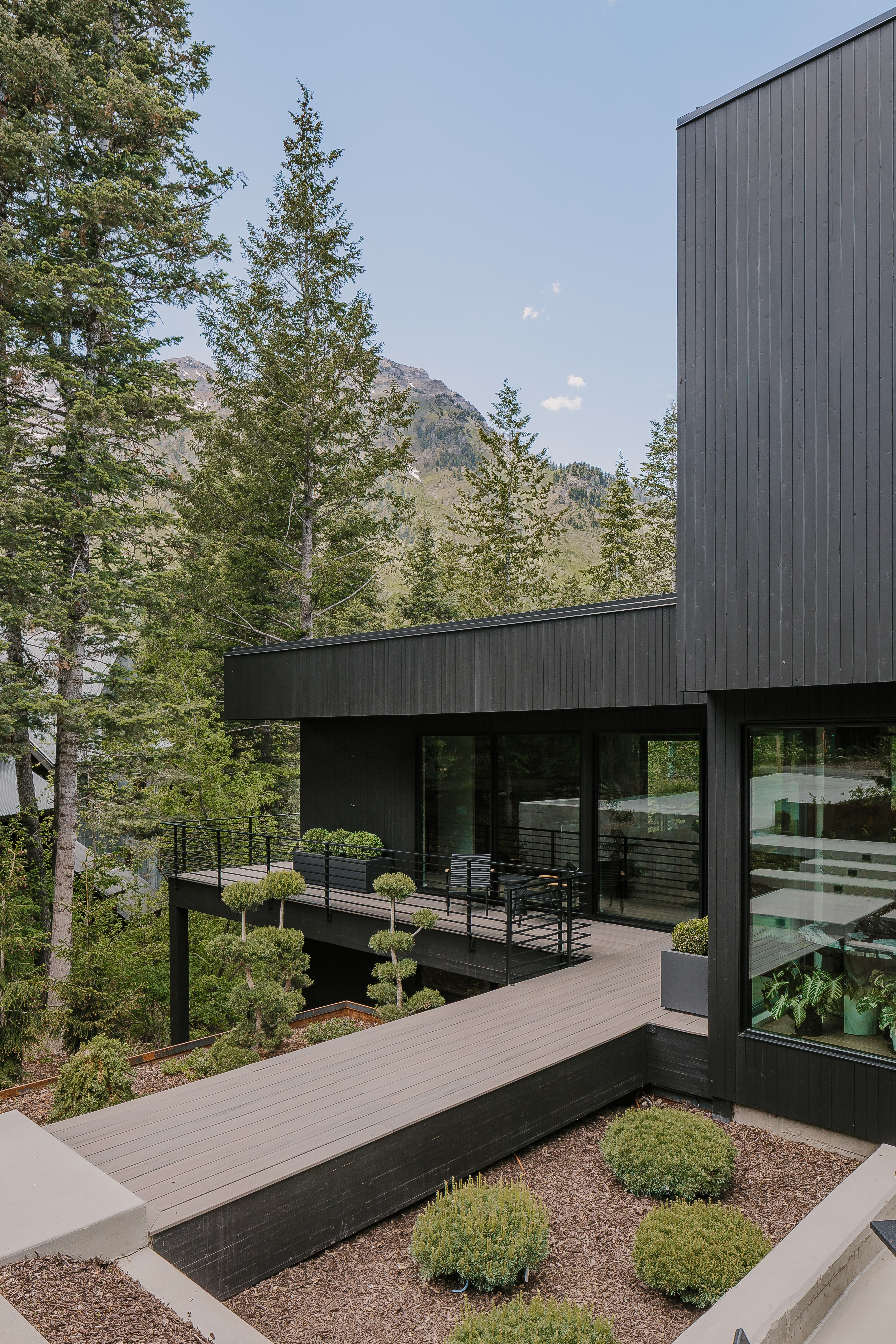Modern exterior featuring dark vertical siding and a multi-level deck