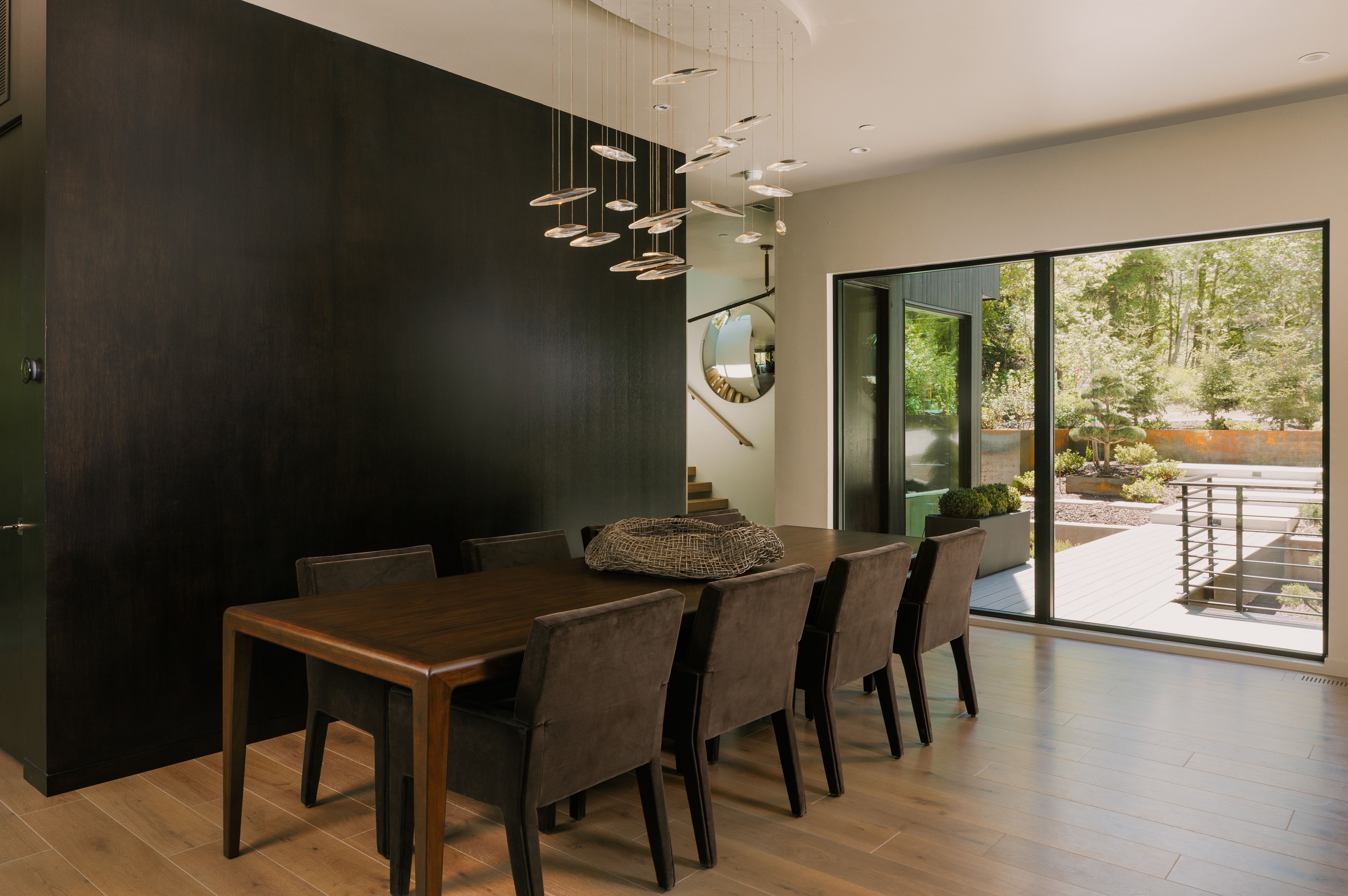 Expansive black accent wall complementing light wood-finish flooring