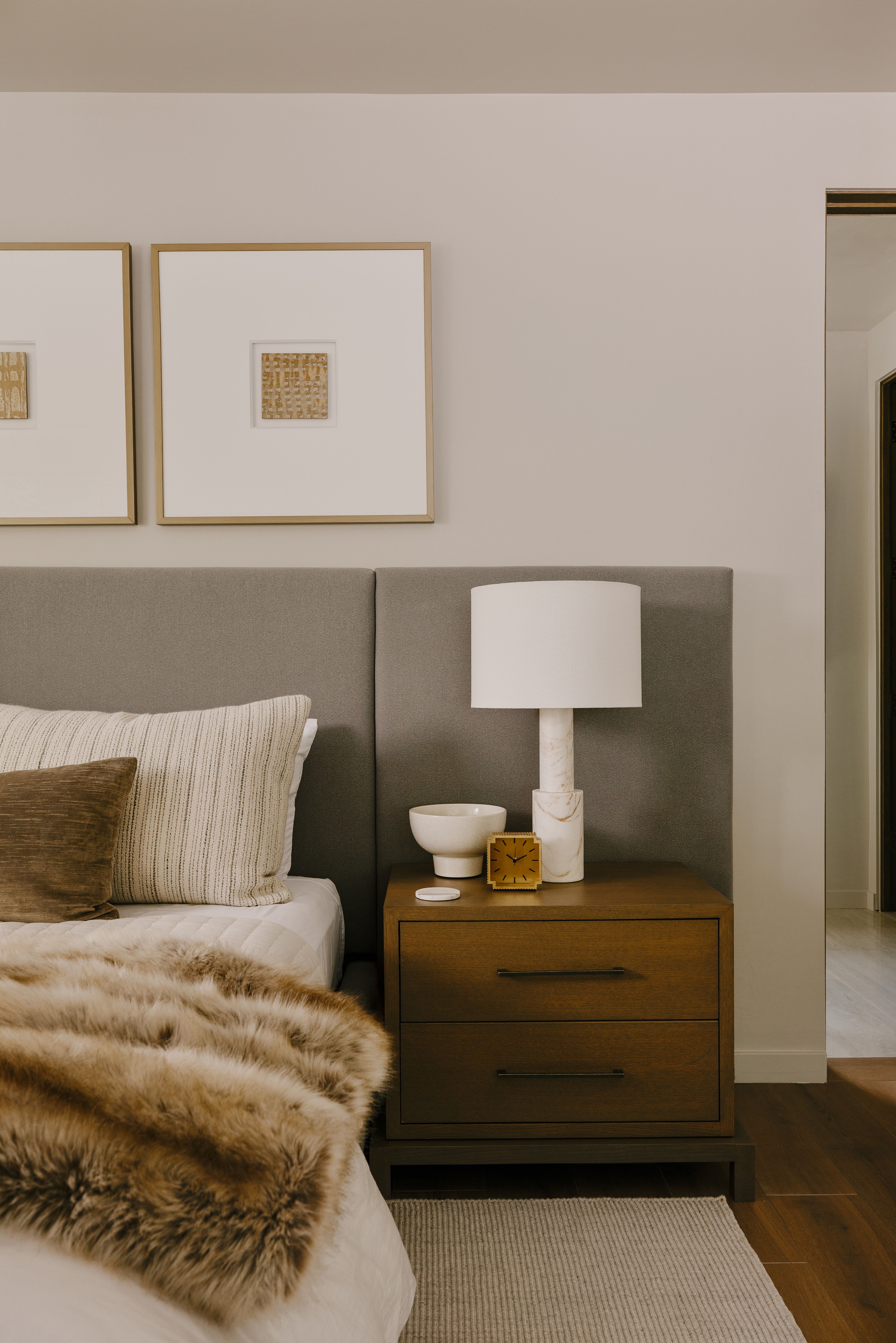 Bedroom featuring a padded headboard, wood-finish nightstand with two drawers, and a rug