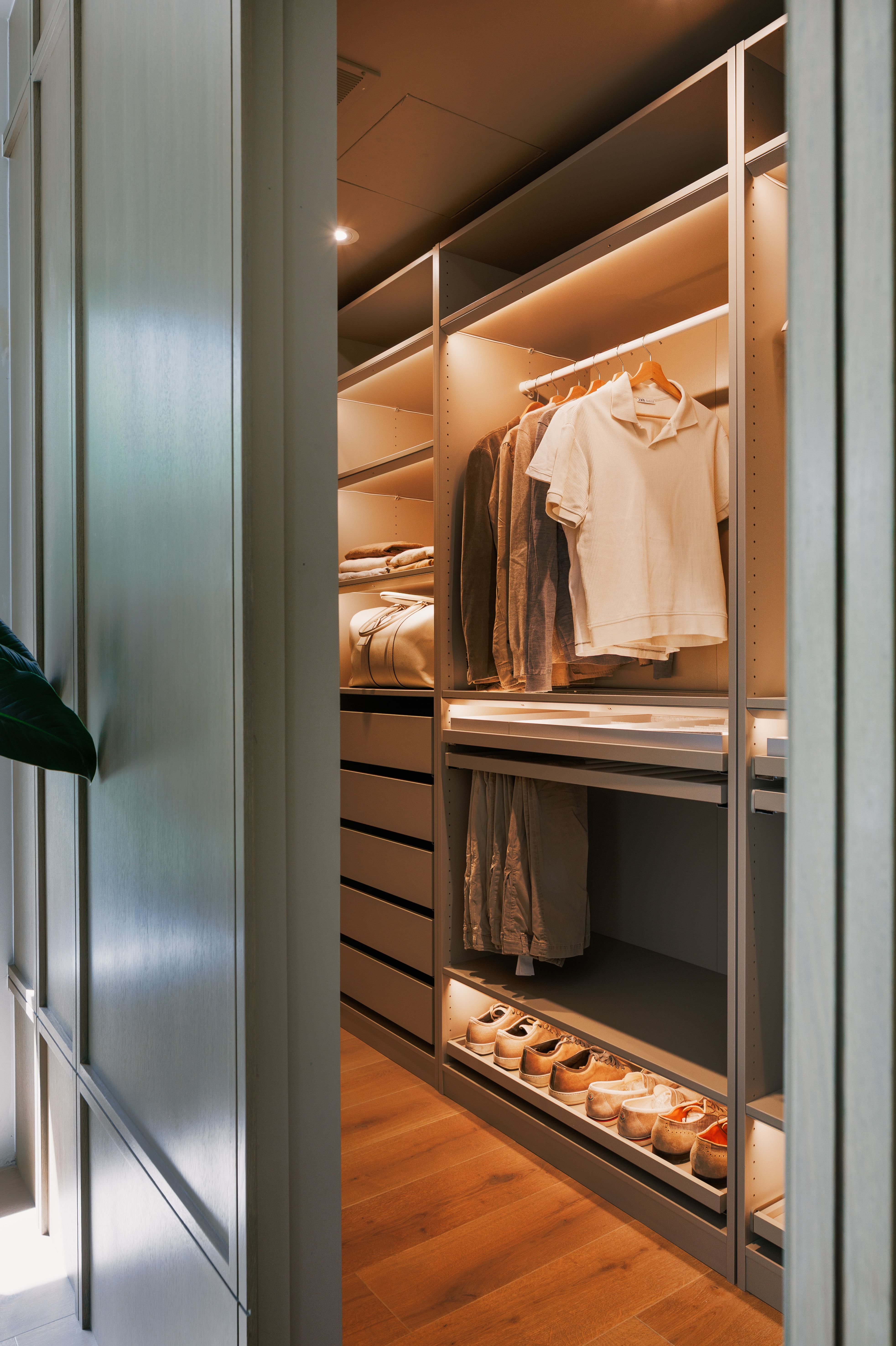Custom closet system featuring recessed lighting, extensive shelving, integrated drawers, hanging storage, and dedicated shoe storage, all set on wood-finish flooring