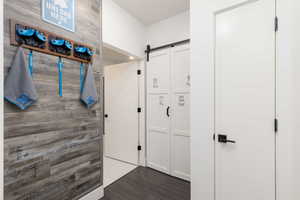 Wall paneling featuring a weathered wood-finish, complemented by sleek white doors with dark hardware