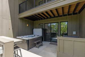 Private patio featuring a built-in hot tub with steps, an outdoor bar counter, and direct access through sliding glass doors