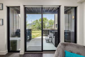 Patio access through sliding glass doors, featuring a hot tub, outdoor bar seating, and mountain scenery